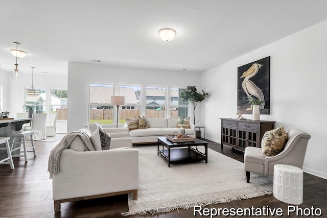 living room with visible vents, baseboards, and wood finished floors