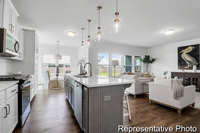 kitchen featuring dark wood-style flooring, stainless steel appliances, light countertops, and a sink