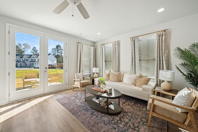 living room featuring ceiling fan, french doors, and light hardwood / wood-style flooring