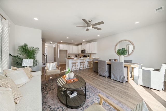 living room with ceiling fan and light wood-type flooring