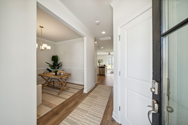 entrance foyer featuring ceiling fan with notable chandelier, dark hardwood / wood-style floors, and crown molding