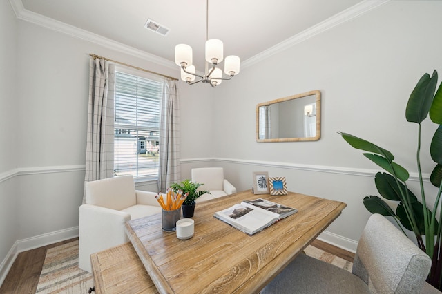 dining space featuring ornamental molding, a notable chandelier, and hardwood / wood-style flooring