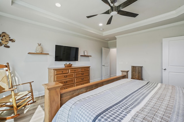 bedroom with baseboards, light wood-style flooring, a tray ceiling, crown molding, and recessed lighting