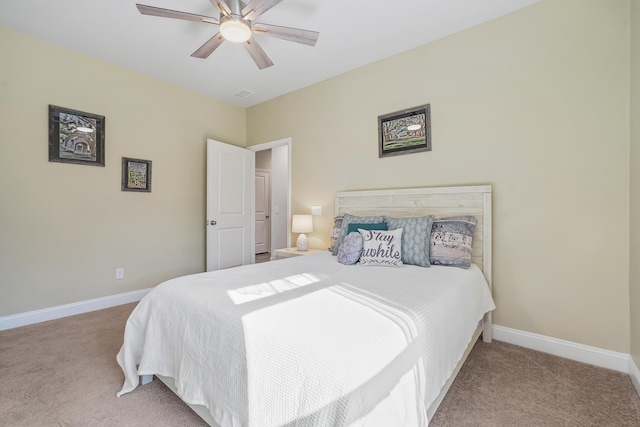 carpeted bedroom featuring a ceiling fan, visible vents, and baseboards