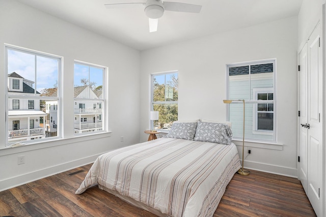 bedroom with ceiling fan, dark hardwood / wood-style floors, and multiple windows