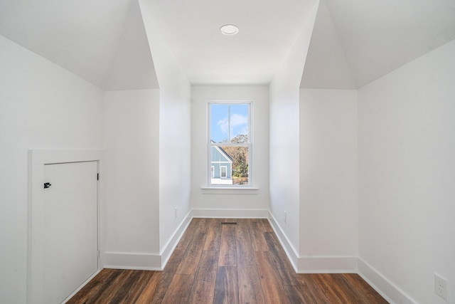 additional living space with vaulted ceiling and dark wood-type flooring