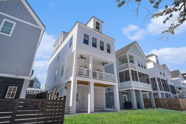 view of front of property with ceiling fan and a front lawn