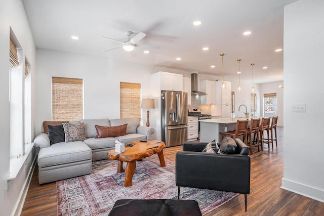 living room with ceiling fan, dark hardwood / wood-style flooring, and sink