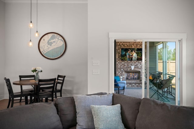 dining room featuring a fireplace, a towering ceiling, baseboards, and wood finished floors