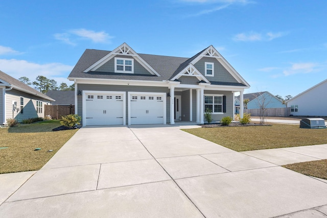 view of front of house with driveway, a garage, fence, and a front yard