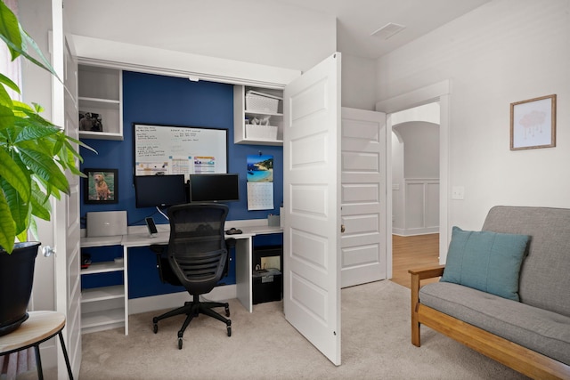 carpeted office space featuring arched walkways and visible vents