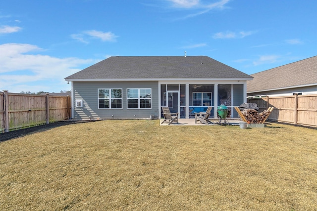 rear view of property featuring a yard, a patio area, a fenced backyard, and a sunroom