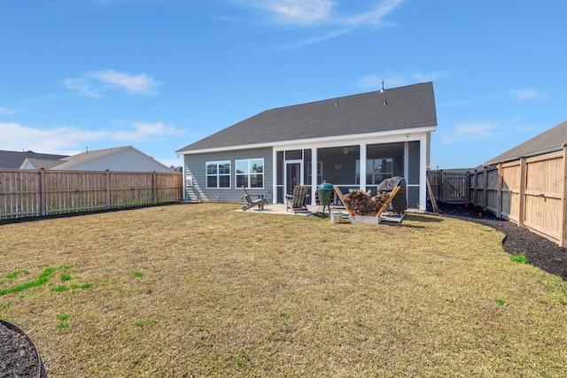 back of house featuring a lawn, a patio area, a fenced backyard, and a sunroom