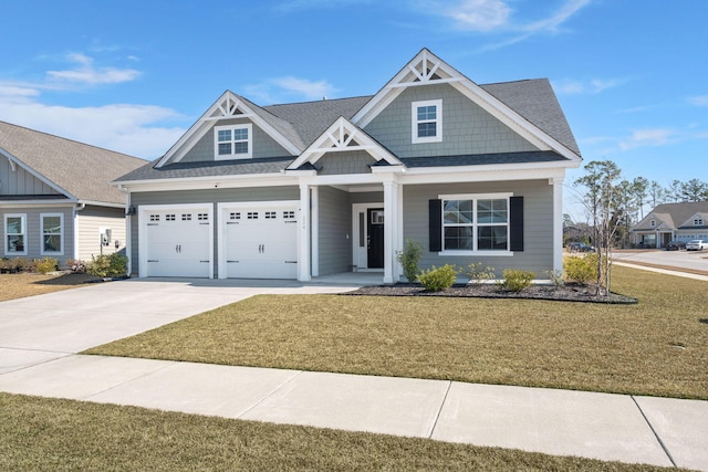 craftsman house with a garage, a front yard, and concrete driveway