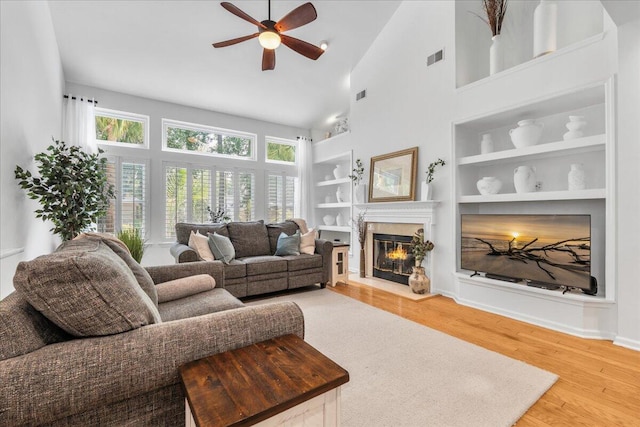 555 Pointe Of Oaks Rd, Summerville, SC 29485 - living area featuring a ceiling fan, built in shelves, wood finished floors, a high end fireplace, and high vaulted ceiling
