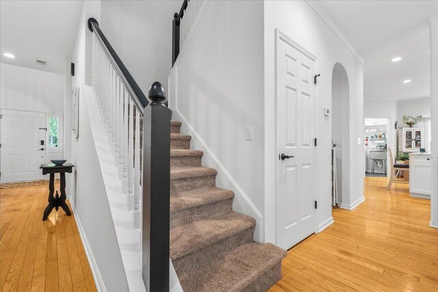 555 Pointe Of Oaks Rd, Summerville, SC 29485 - staircase featuring hardwood / wood-style flooring, arched walkways, recessed lighting, baseboards, and ornamental molding
