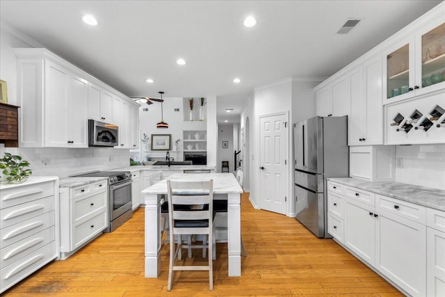 555 Pointe Of Oaks Rd, Summerville, SC 29485 - kitchen featuring stainless steel appliances, white cabinets, tasteful backsplash, a center island, and a sink