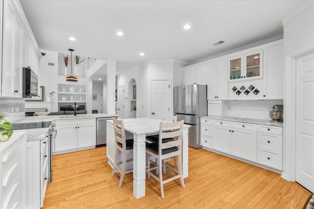 555 Pointe Of Oaks Rd, Summerville, SC 29485 - kitchen with appliances with stainless steel finishes, ornamental molding, white cabinets, arched walkways, and tasteful backsplash