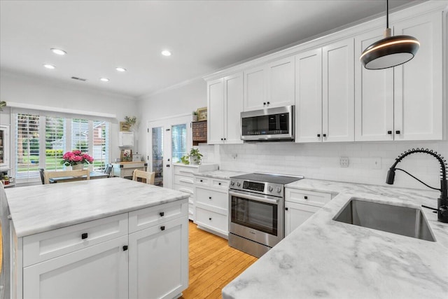 555 Pointe Of Oaks Rd, Summerville, SC 29485 - kitchen with appliances with stainless steel finishes, a sink, crown molding, white cabinetry, and decorative backsplash