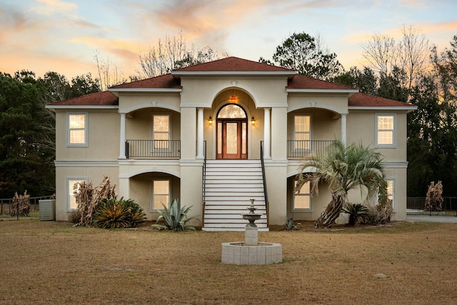 mediterranean / spanish-style house featuring a lawn and a balcony