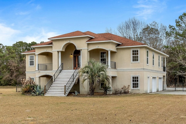 mediterranean / spanish home with a garage and a front lawn