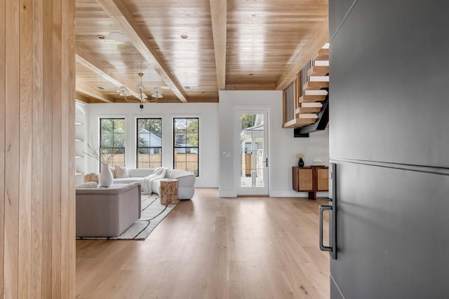 unfurnished living room with beam ceiling, wood ceiling, and light hardwood / wood-style floors