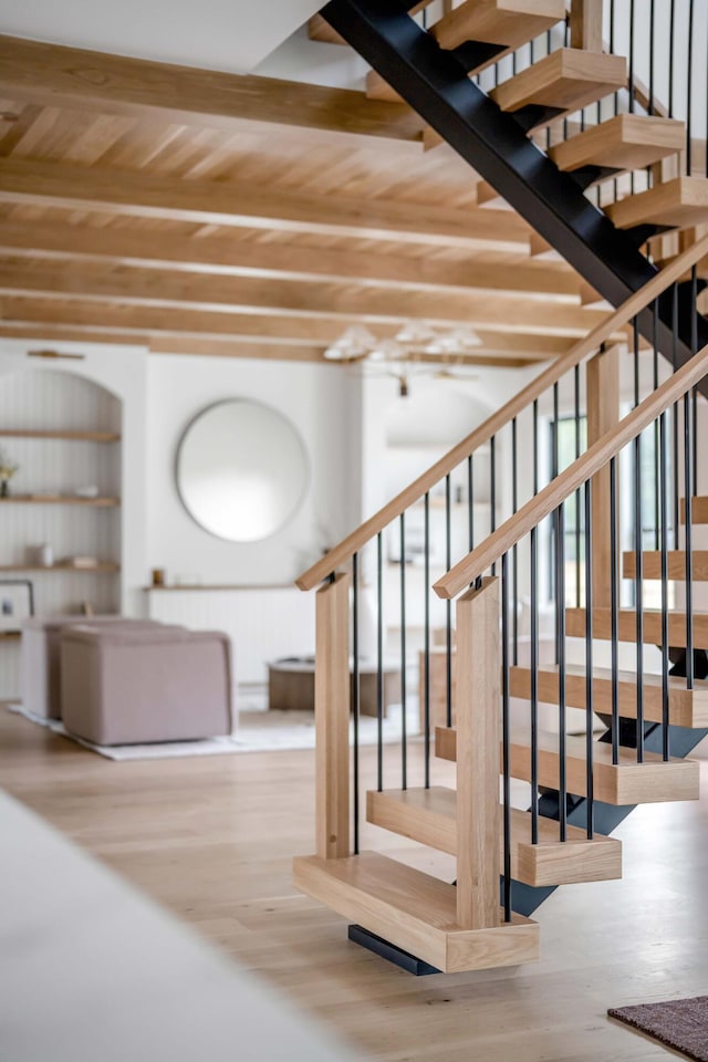 stairs with beamed ceiling, wood-type flooring, and wood ceiling