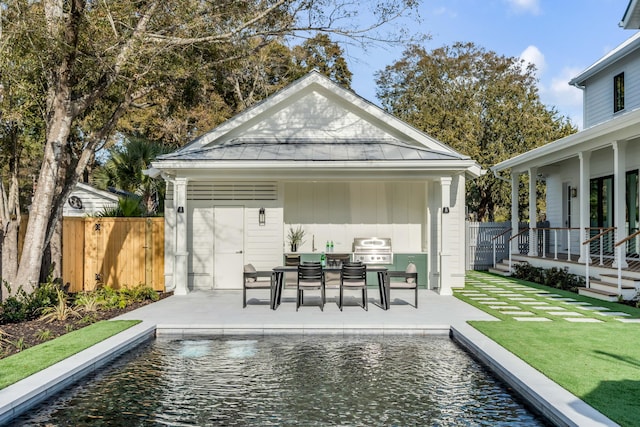 view of patio / terrace with area for grilling, a fenced in pool, and an outdoor structure