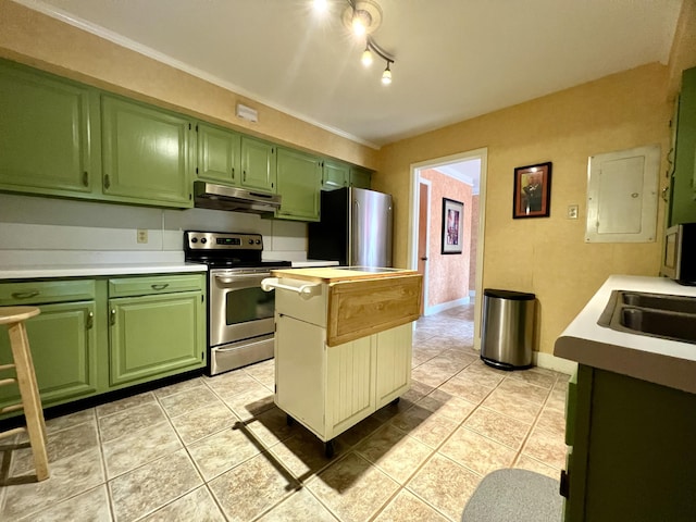 kitchen with under cabinet range hood, light countertops, light tile patterned floors, green cabinets, and appliances with stainless steel finishes