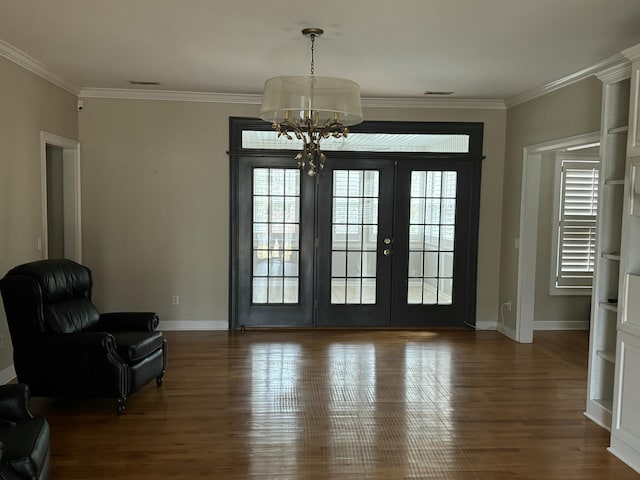 doorway featuring crown molding, baseboards, and wood finished floors