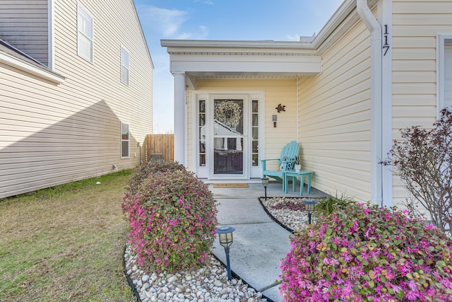 view of exterior entry featuring a yard