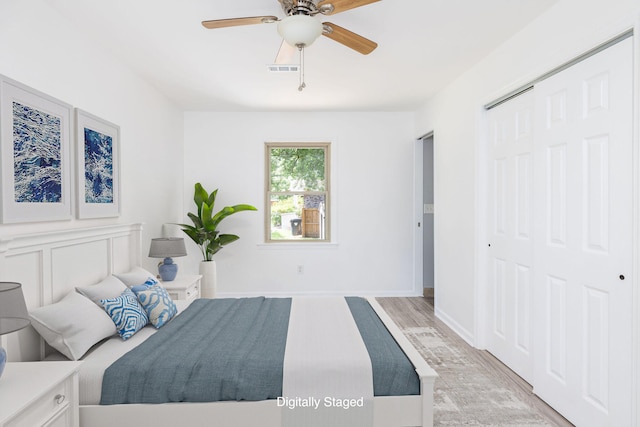 bedroom featuring a closet, light wood-type flooring, and ceiling fan