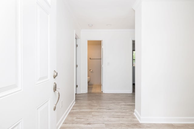 hallway featuring ornamental molding and light wood-type flooring