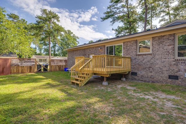 rear view of house with a deck and a yard