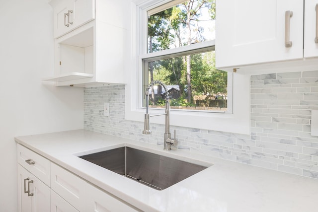 kitchen featuring white cabinetry, tasteful backsplash, sink, and a healthy amount of sunlight