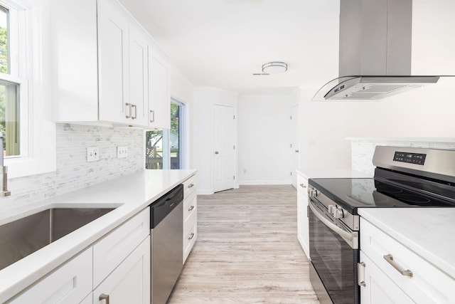 kitchen featuring plenty of natural light, white cabinetry, stainless steel appliances, and island range hood