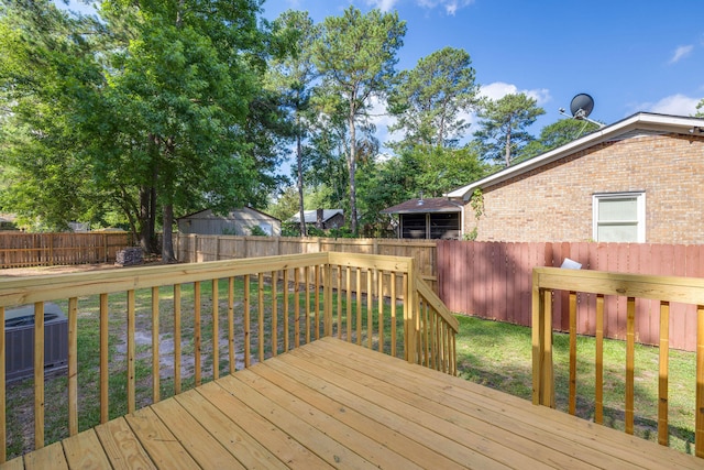 wooden terrace featuring a yard and cooling unit