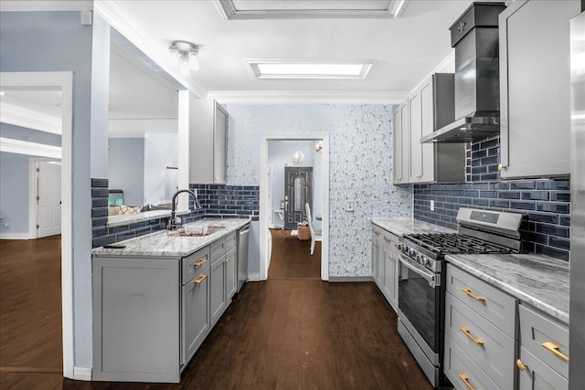 kitchen featuring wall chimney range hood, stainless steel appliances, sink, gray cabinets, and dark hardwood / wood-style flooring