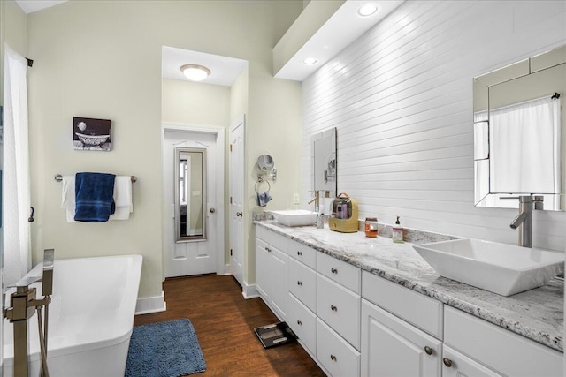 bathroom with vanity, a tub, and hardwood / wood-style floors