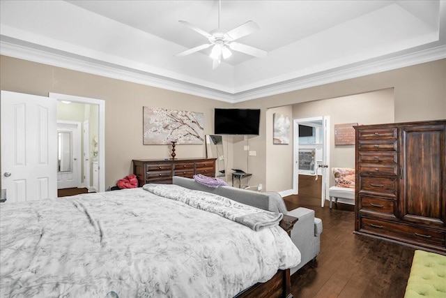 bedroom featuring dark hardwood / wood-style flooring, a tray ceiling, and ceiling fan