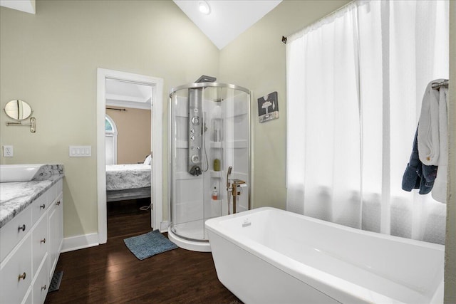 bathroom with vanity, vaulted ceiling, separate shower and tub, and hardwood / wood-style floors