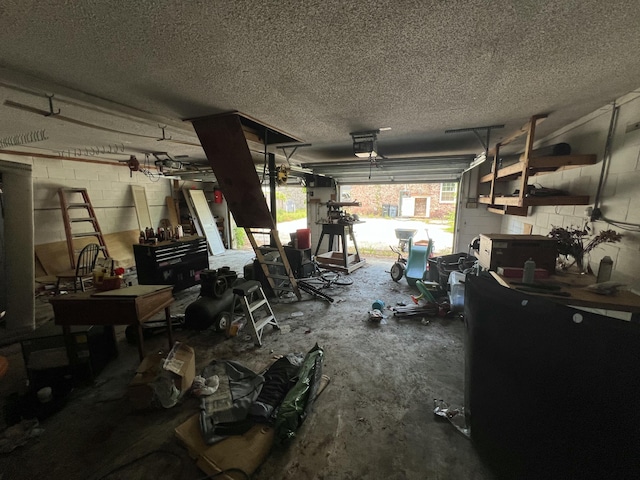 garage featuring concrete block wall, a workshop area, and a garage door opener