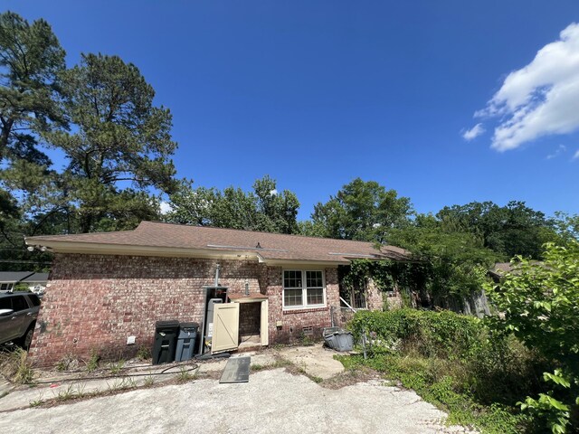 back of house with brick siding and crawl space