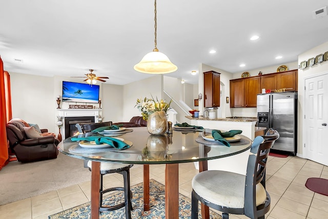 carpeted dining space with ceiling fan