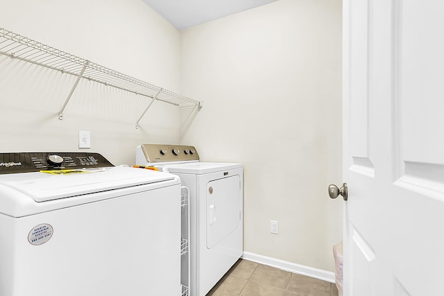 laundry room with separate washer and dryer and light tile patterned flooring