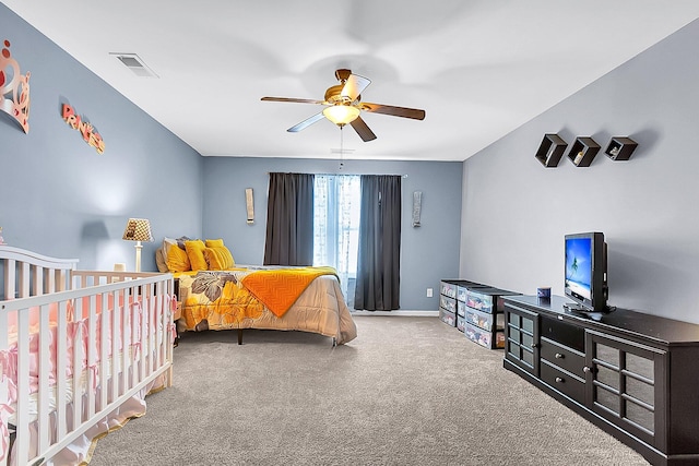 bedroom featuring carpet, a nursery area, and ceiling fan