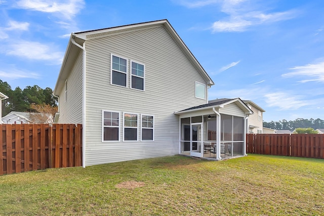 rear view of property featuring a sunroom and a lawn