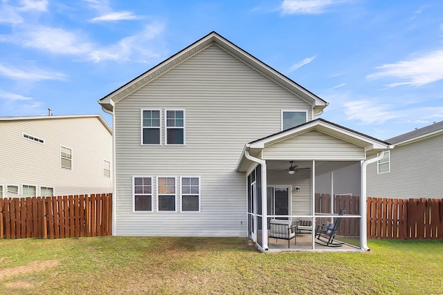 rear view of property featuring a lawn, a patio area, a sunroom, and ceiling fan