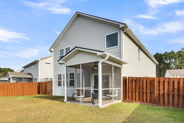 back of property with a lawn, a sunroom, and a patio