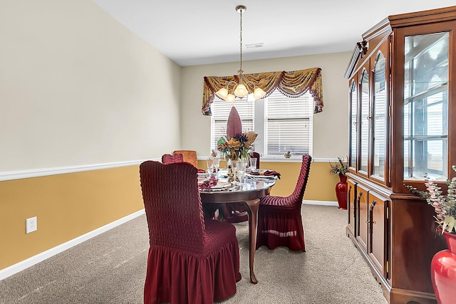 carpeted dining area featuring a wealth of natural light and a notable chandelier